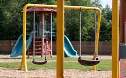 Icon depicting a children's playground with swings and slides